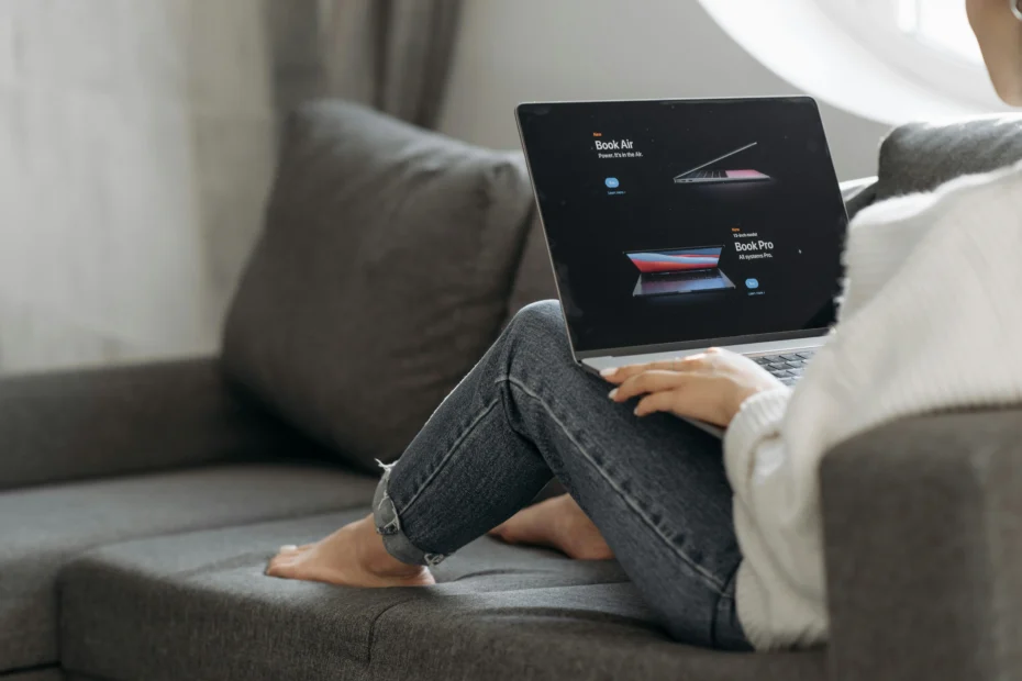 Person auf Sofa mit Laptop beim Vergleich zweier Produkte in ansprechendem Design - Preiswahrnehmung und